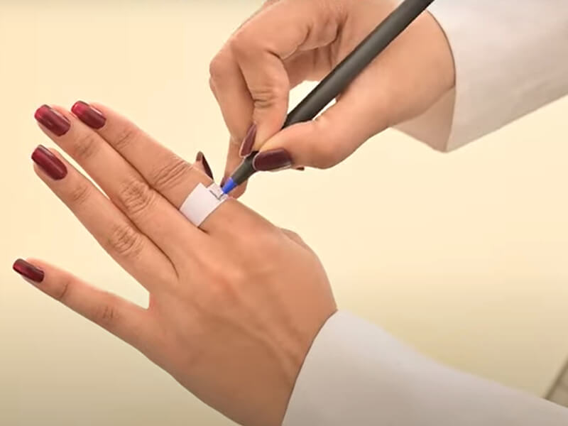 اندازه‌گیری سایز انگشتر با پیچیدن نوار کاغذی دور انگشت و علامت‌گذاری محل تقاطع برای محاسبه دقیق محیط انگشت