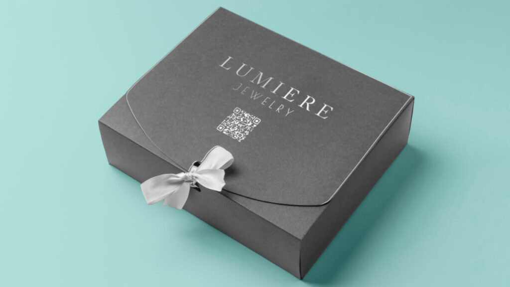 جعبه لاکچری LUMIERE Jewelry، جعبه طوسی با طراحی شیک و روبان سفید و چاپ QR کد، مناسب برندهای جواهرات لوکس.